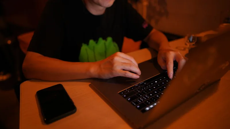 一位疲憊的男性在辦公室加班,表情顯得壓力大
