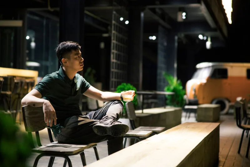 男性在聚會中看著酒杯思考是否該喝酒